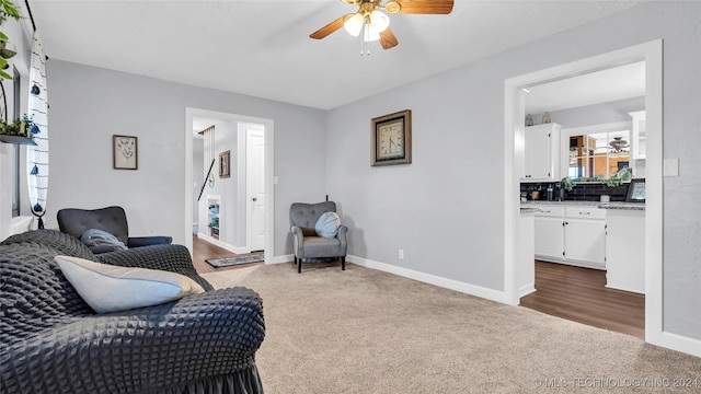 carpeted living room with ceiling fan