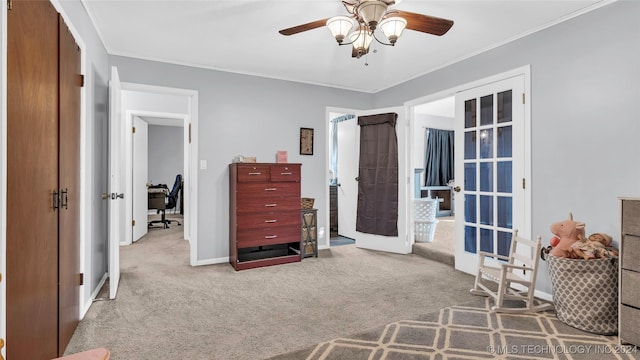 carpeted bedroom featuring french doors, ceiling fan, and ornamental molding