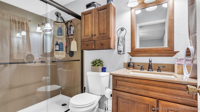 bathroom featuring vanity, toilet, and walk in shower