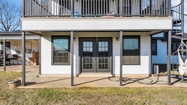 entrance to property with a patio area, a balcony, and french doors