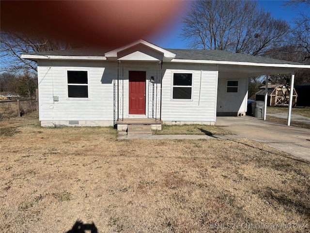 view of front of home with a carport and a lawn