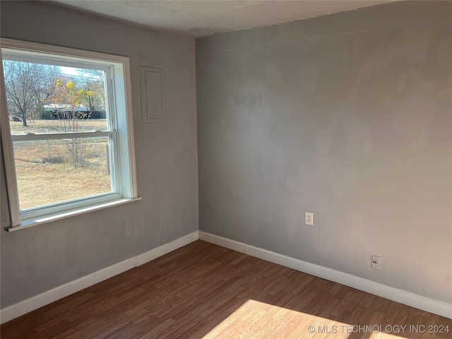 empty room featuring dark wood-type flooring and a healthy amount of sunlight