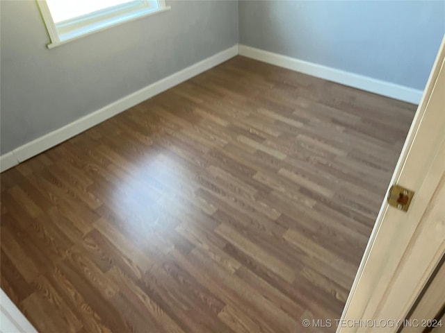 spare room with dark wood-type flooring