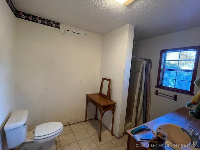 bathroom with a shower with shower curtain, tile patterned floors, vanity, a textured ceiling, and toilet