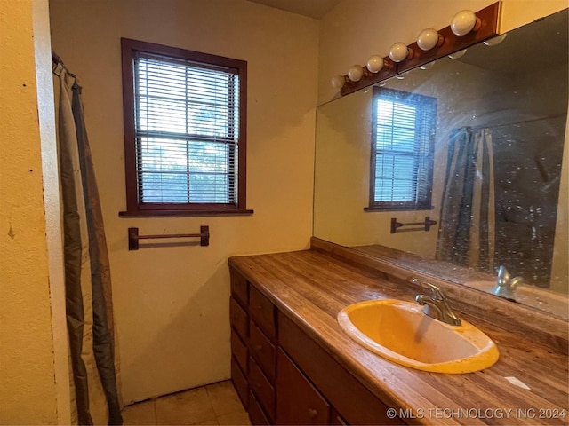 bathroom featuring tile patterned flooring, vanity, and a wealth of natural light