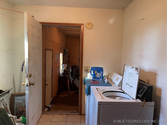 laundry room with independent washer and dryer and light tile patterned floors