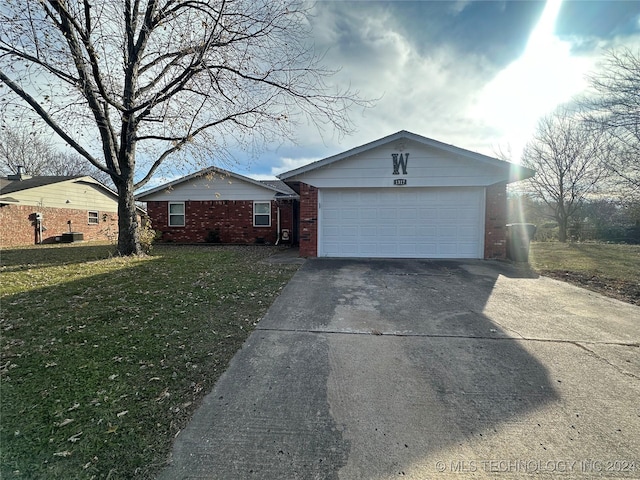 ranch-style home with a garage and a front lawn