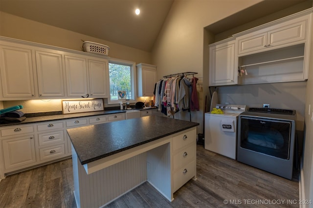 kitchen with white cabinetry, a center island, dark hardwood / wood-style flooring, independent washer and dryer, and lofted ceiling