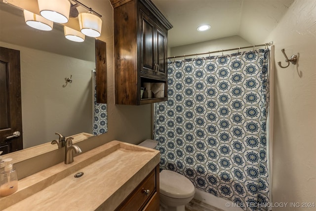 bathroom with vanity, vaulted ceiling, and toilet