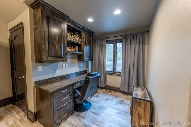 office featuring built in desk and light hardwood / wood-style floors