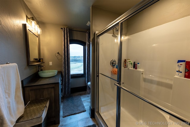 bathroom with tile patterned flooring, vanity, toilet, and a shower with shower door