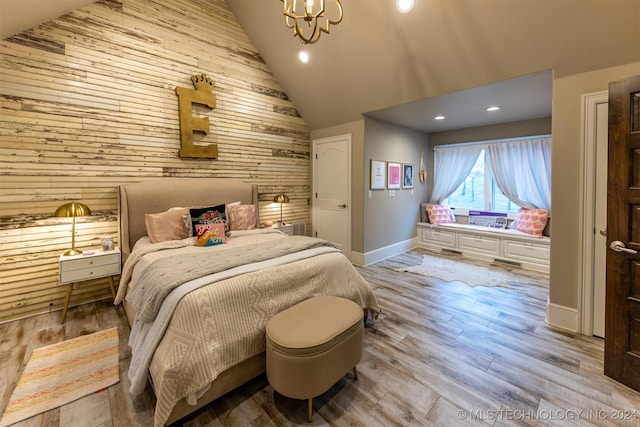 bedroom featuring wood-type flooring, high vaulted ceiling, an inviting chandelier, and wooden walls