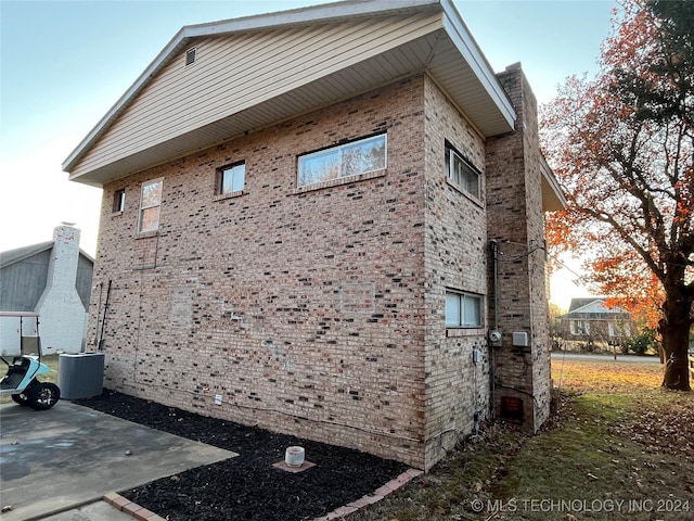 view of property exterior with cooling unit and a patio