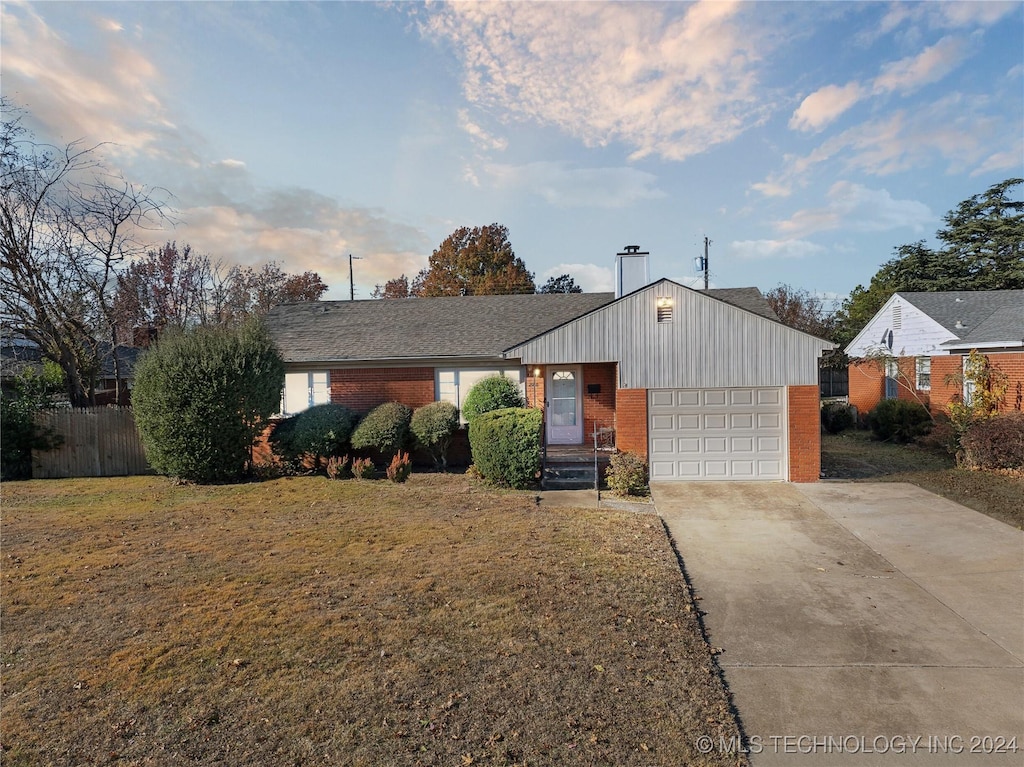 single story home with a garage and a front lawn