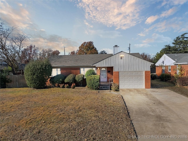 single story home with a garage and a front lawn