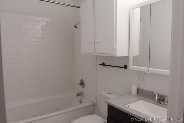 full bathroom featuring tiled shower / bath combo, toilet, and vanity