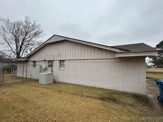 view of property exterior with a lawn and cooling unit