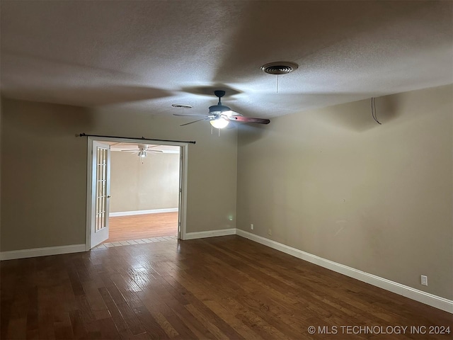 empty room featuring a textured ceiling and dark hardwood / wood-style flooring