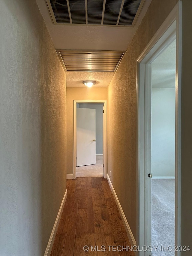 hallway with dark hardwood / wood-style flooring