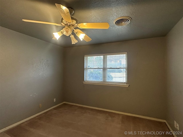 carpeted empty room with ceiling fan and a textured ceiling