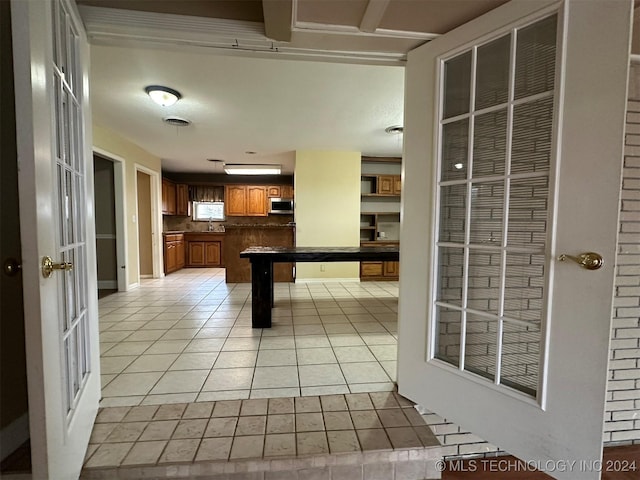 kitchen featuring french doors, light tile patterned floors, and sink