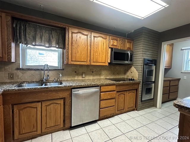 kitchen with decorative backsplash, light tile patterned floors, stainless steel appliances, and sink