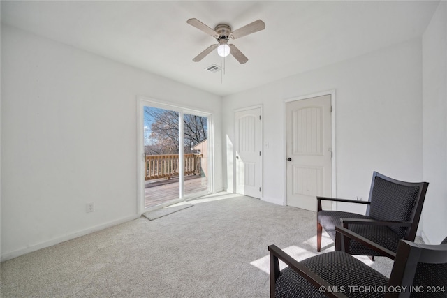 living area with ceiling fan and light carpet