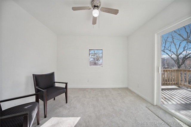 living area with ceiling fan and light carpet