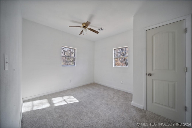 unfurnished room with a wealth of natural light, ceiling fan, and light colored carpet