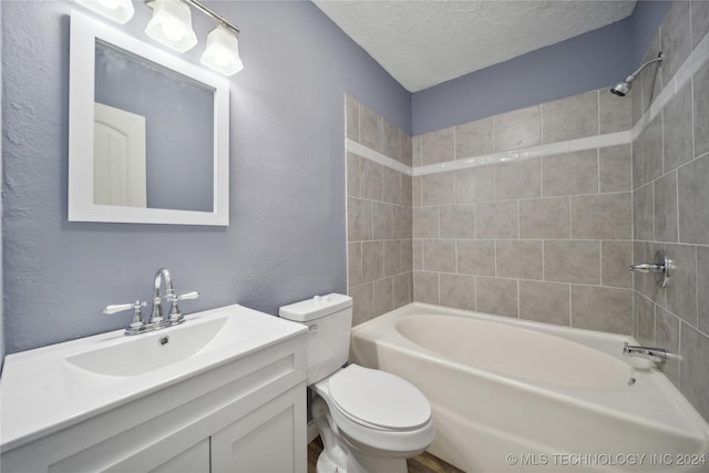 full bathroom featuring vanity, tiled shower / bath combo, a textured ceiling, and toilet