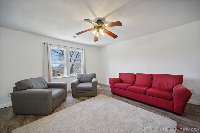 living room featuring dark hardwood / wood-style flooring and ceiling fan