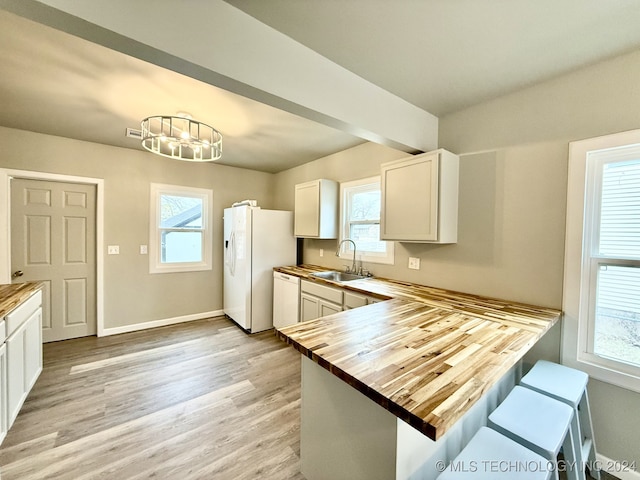 kitchen with white cabinets, butcher block countertops, plenty of natural light, and sink