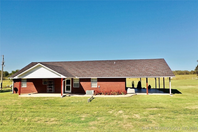 rear view of property with cooling unit, a patio area, and a yard