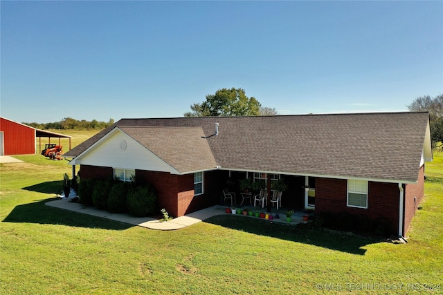 back of property featuring an outbuilding and a lawn