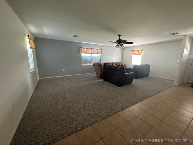 unfurnished living room with carpet flooring, plenty of natural light, and ceiling fan