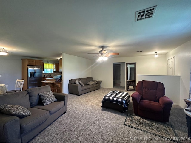 carpeted living room featuring ceiling fan and sink