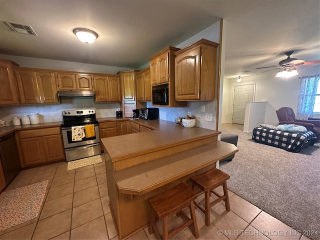 kitchen with ceiling fan, light tile patterned floors, stainless steel appliances, and kitchen peninsula