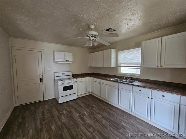 kitchen featuring white cabinets, dark hardwood / wood-style flooring, white range oven, and sink