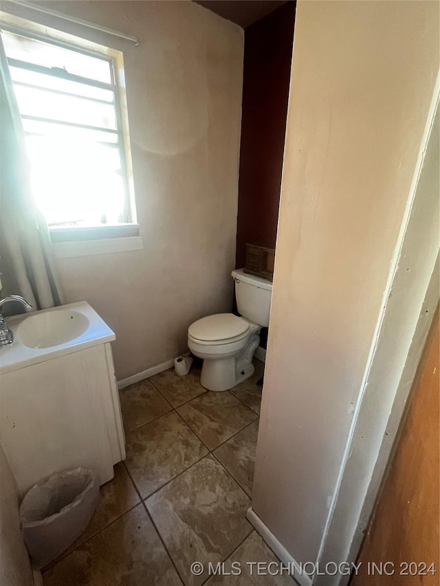 bathroom featuring tile patterned floors, vanity, and toilet