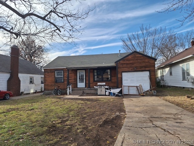 back of house featuring a garage and a lawn