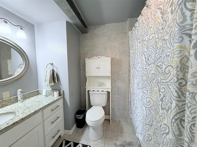 bathroom with tile patterned floors, vanity, toilet, and tile walls