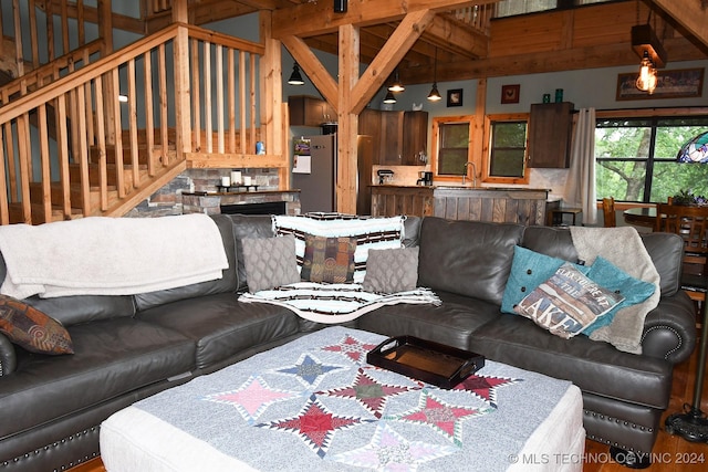 living room featuring beam ceiling, sink, and high vaulted ceiling