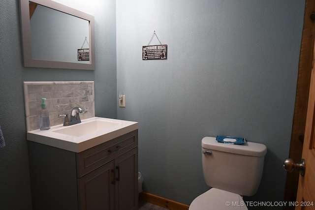 bathroom with vanity, tasteful backsplash, and toilet