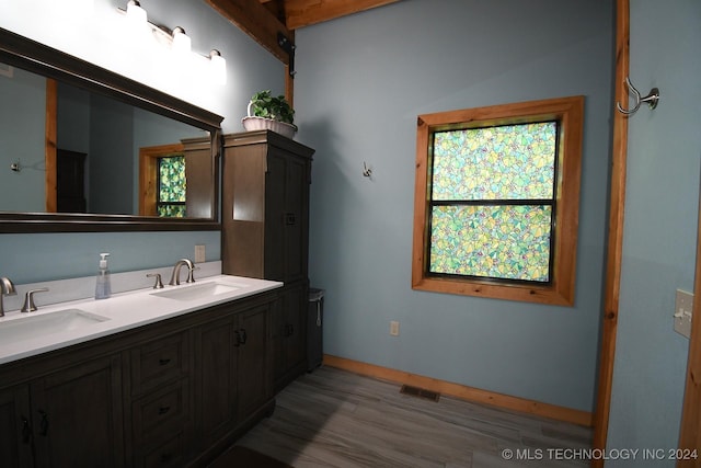 bathroom with beam ceiling, vanity, and hardwood / wood-style flooring