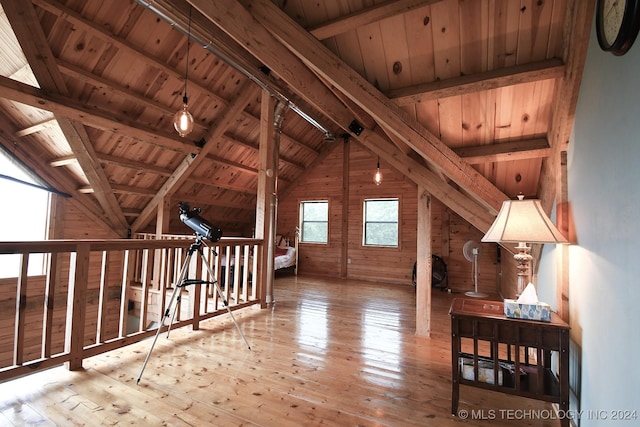 bonus room featuring vaulted ceiling with beams, wooden walls, wooden ceiling, and light wood-type flooring