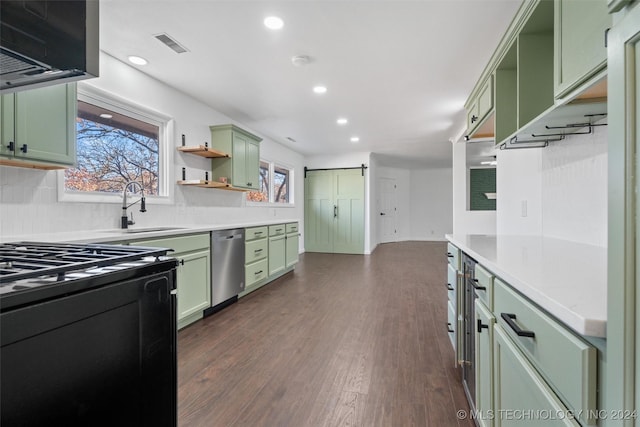 kitchen with dishwasher, sink, a barn door, green cabinets, and dark hardwood / wood-style floors