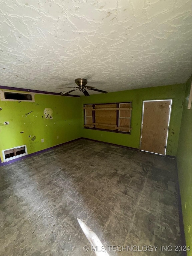 unfurnished living room with a textured ceiling and ceiling fan