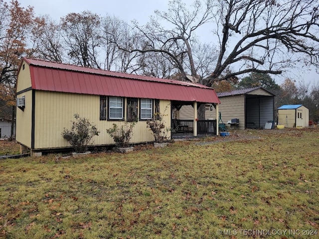 exterior space featuring a front lawn, a carport, and a storage unit