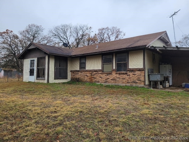 view of front of property with a front yard and a carport