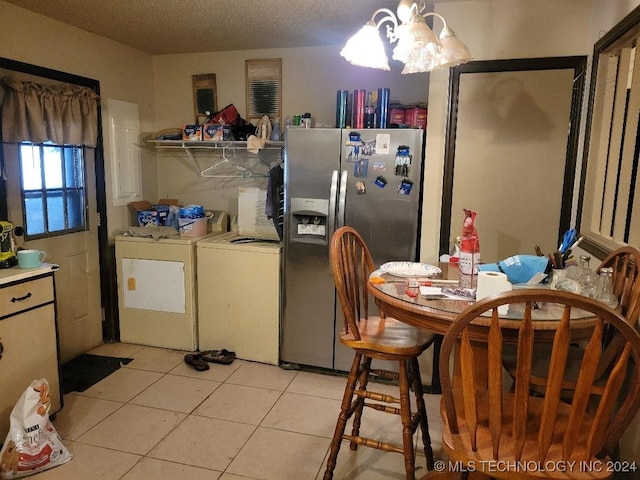 kitchen with washer and clothes dryer, stainless steel refrigerator with ice dispenser, light tile patterned floors, a textured ceiling, and a notable chandelier